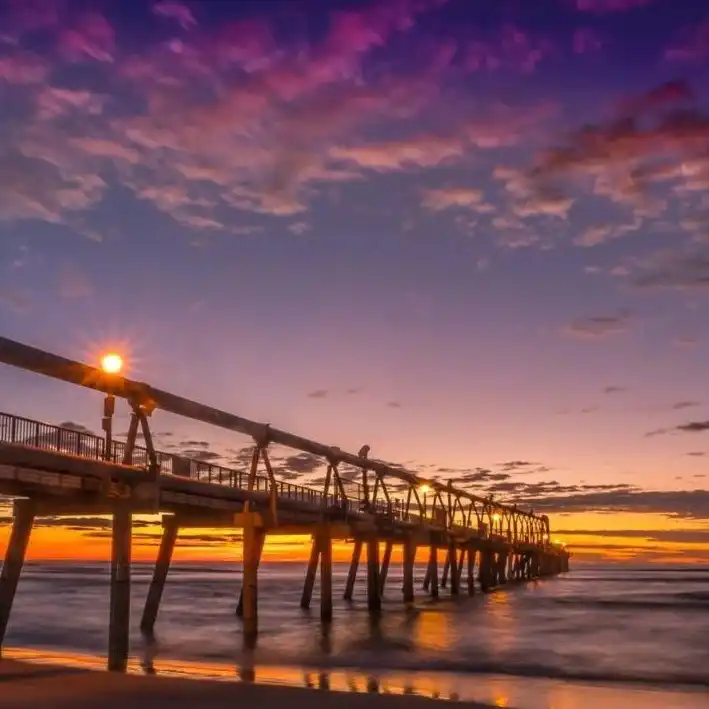 A vibrant golden sunset over the ocean at The Spit, Gold Coast, representing the coastal heart and mission of the Sunny Link surf lifestyle brand.